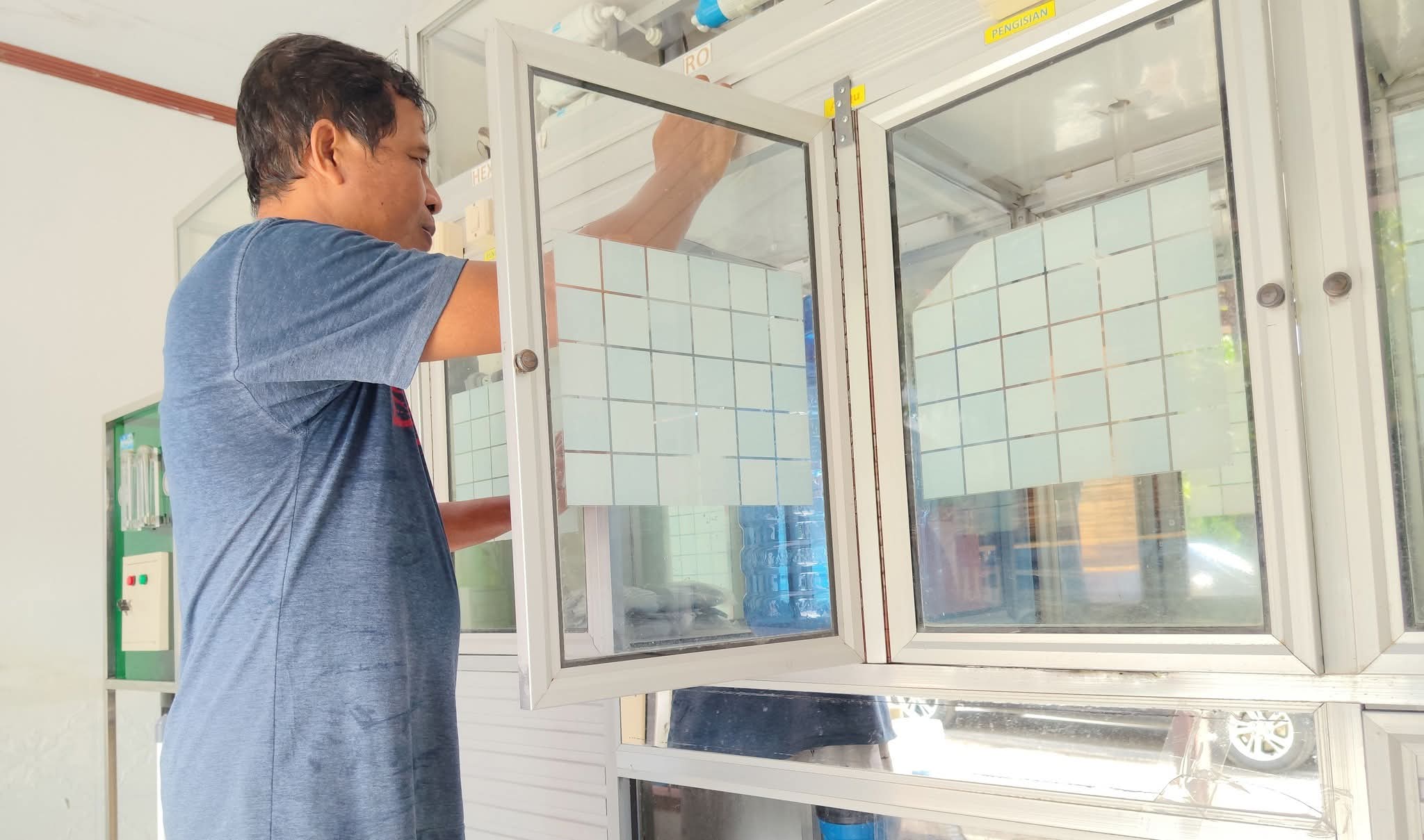 Abd. Rahman Baderan saat mengisi ulang air minum di depotnya, Minggu (14/6/2026). (Foto: Isam/Diskominfotik).
